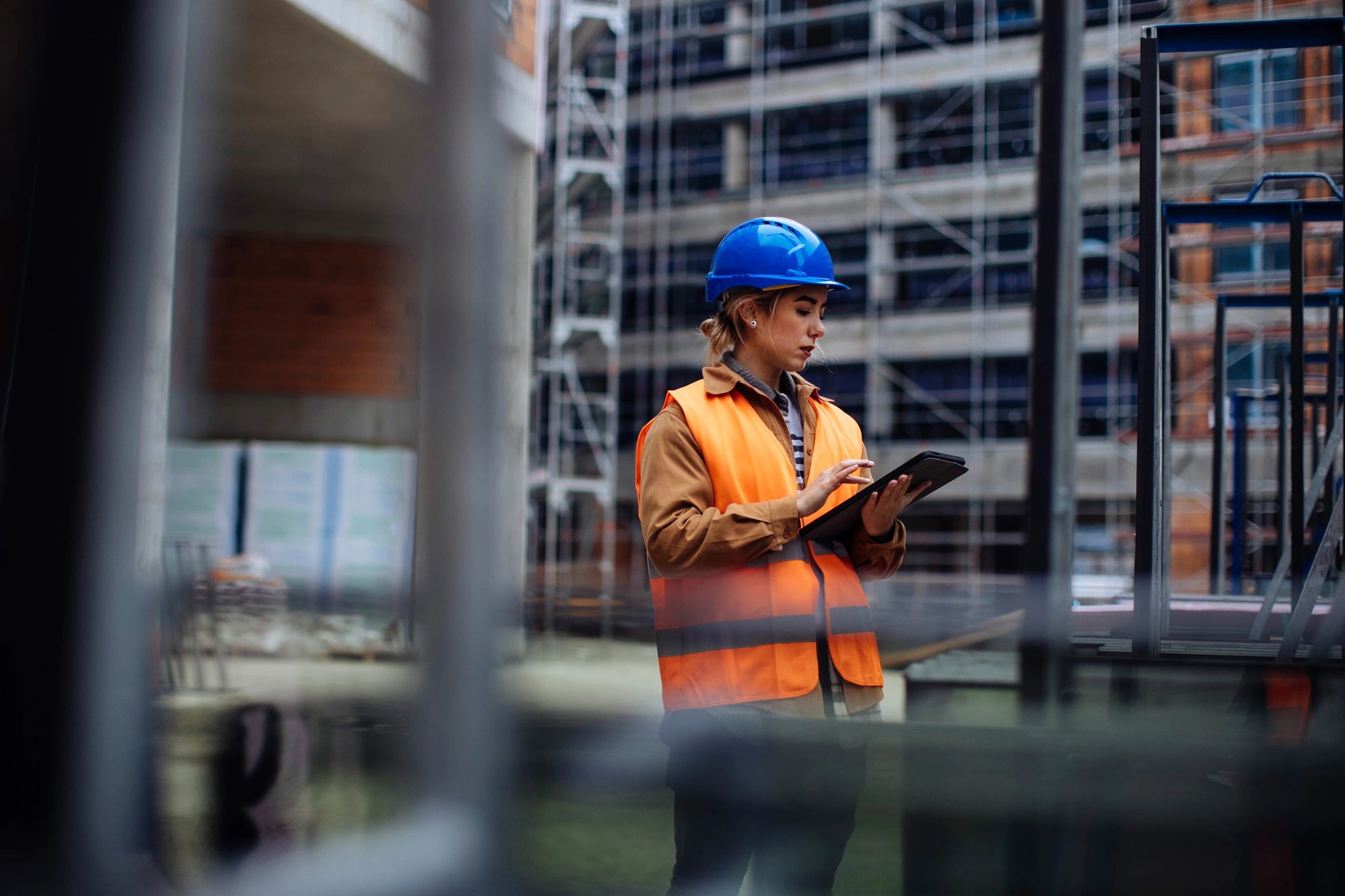 Contractor reviewing project details on a tablet at a construction site